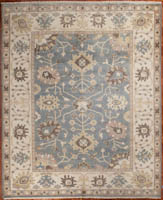 Oushak design on a soft blue background, ivory border with stylized lotus flowers.